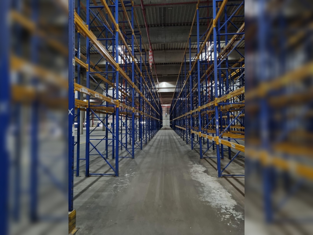 Zentrale Gangansicht zwischen Jungheinrich Delta Regalen, gebraucht, Rahmen blau, Traversen gelb.